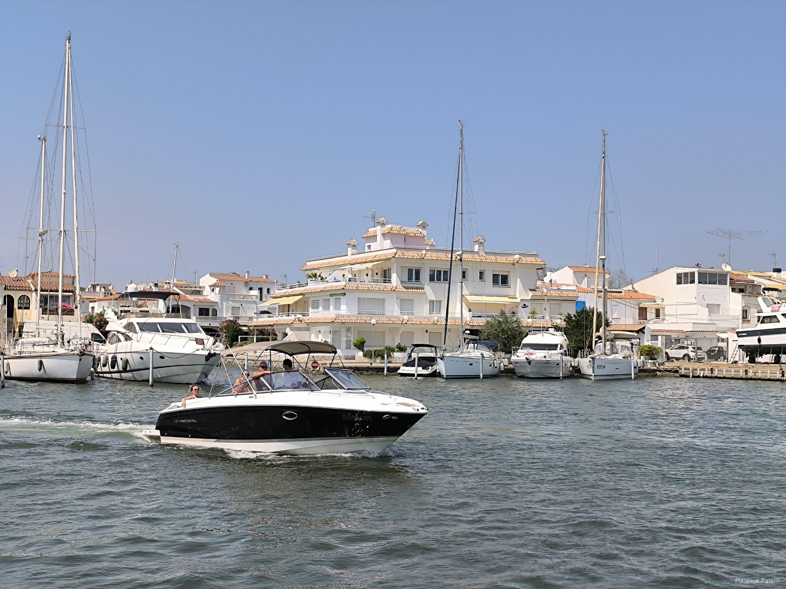 Maison rénovée à Empuriabrava au bord d'un canal, avec façade blanche et architecture méditerranéenne.