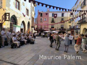 une place de Castello d'Empuries pendant la fête des troubadour avec un orchestre et des gens en train de danser